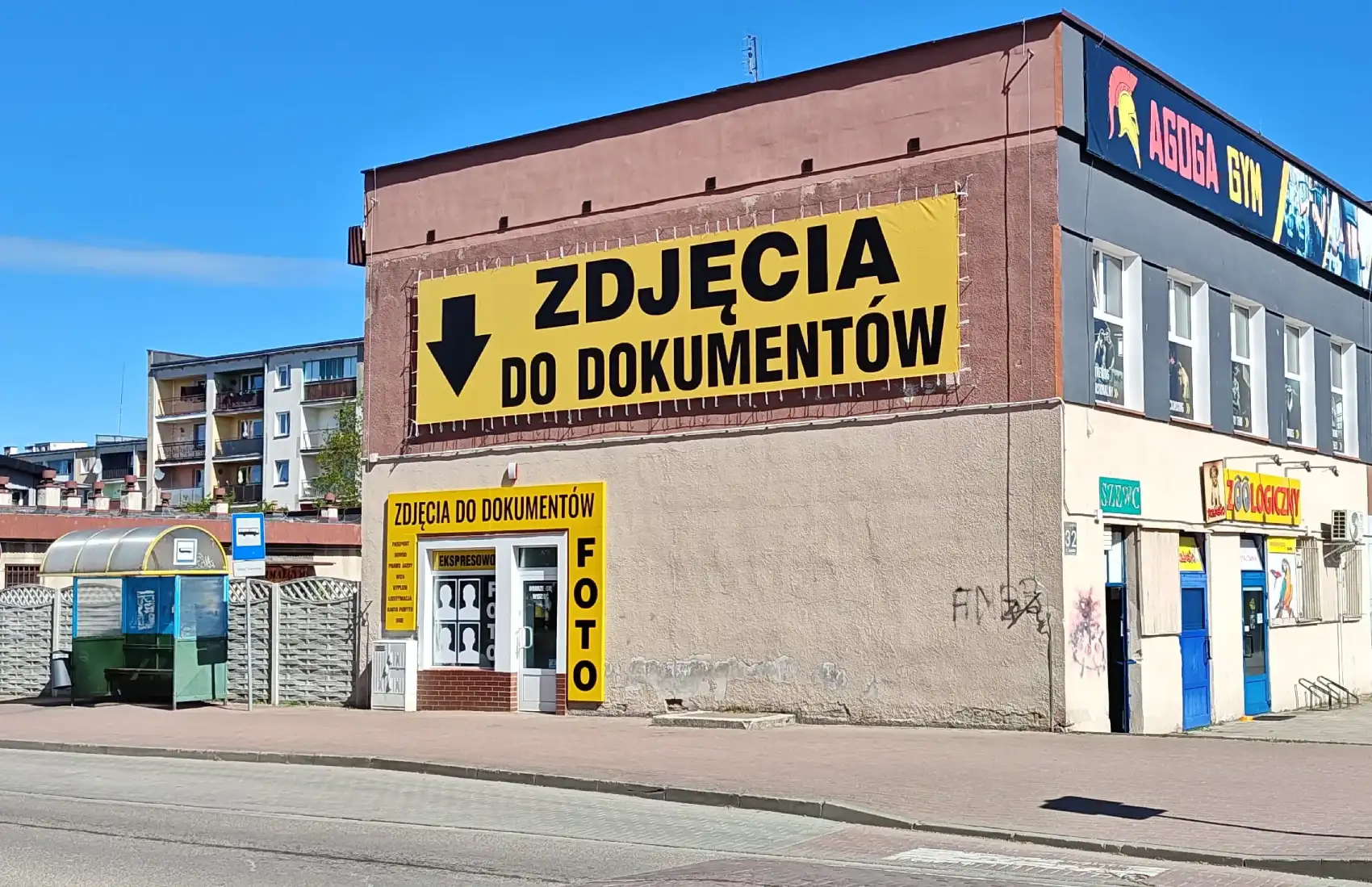Fotograf Lębork - studio zdjęć do dokumentów przy ul. Czołgistów 32. Widoczny charakterystyczny żółty baner reklamowy nad wejściem do salonu.